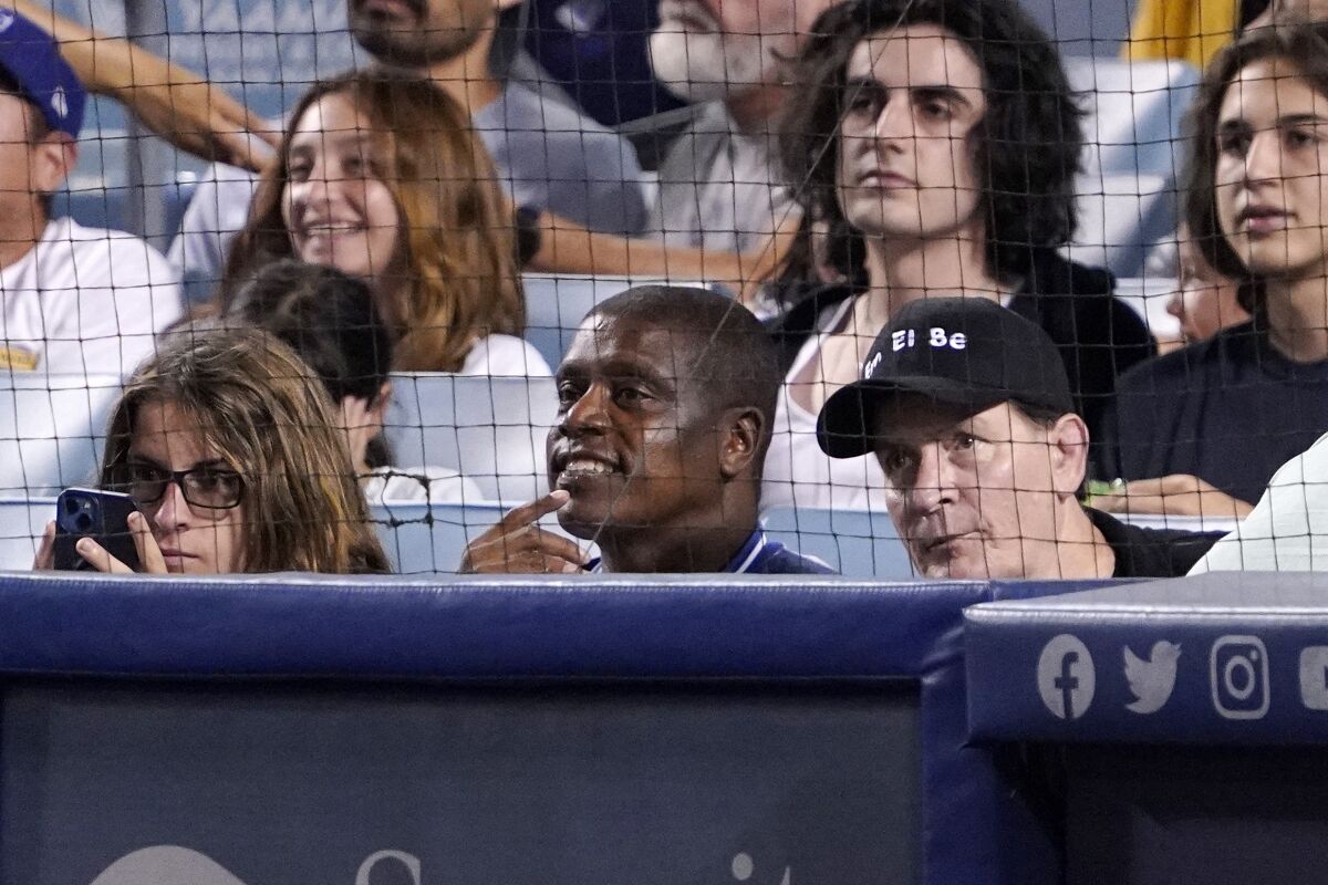 Actor Charlie Sheen, right, watches a game with best friend Tony Todd, middle, at Dodger Stadium on Sept. 2, 2022.